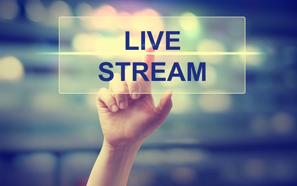 Finger on hand touching text stating Live Stream.